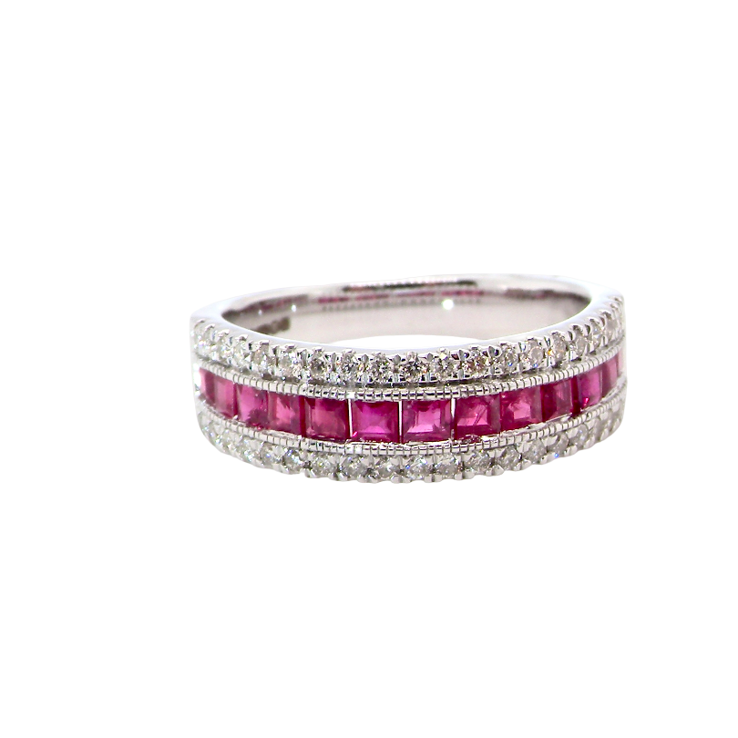 An 18 carat white gold half hoop ring. A triple row design with a line of channel set calibre cut rubies running along the centre ,
