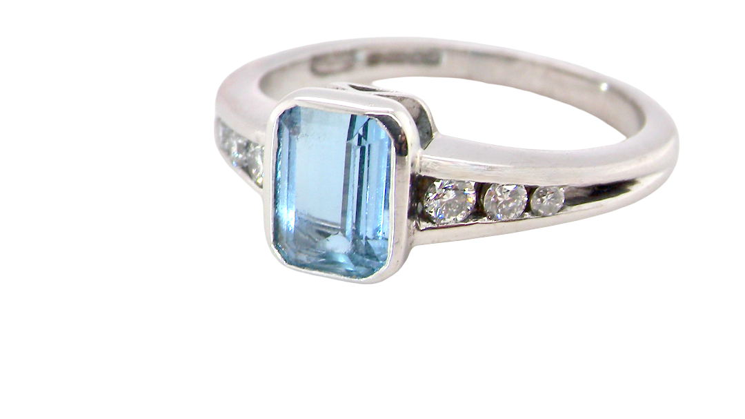 An 18 carat white gold ring, features a rectangular step cut aquamarine, measures 7x5mm (st one carat) sky blue,