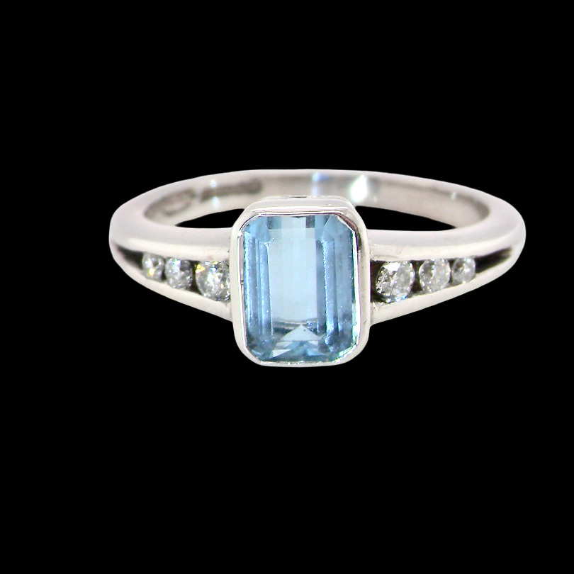 An 18 carat white gold ring, features a rectangular step cut aquamarine, measures 7x5mm (st one carat) , fine clarity. Rim setting.