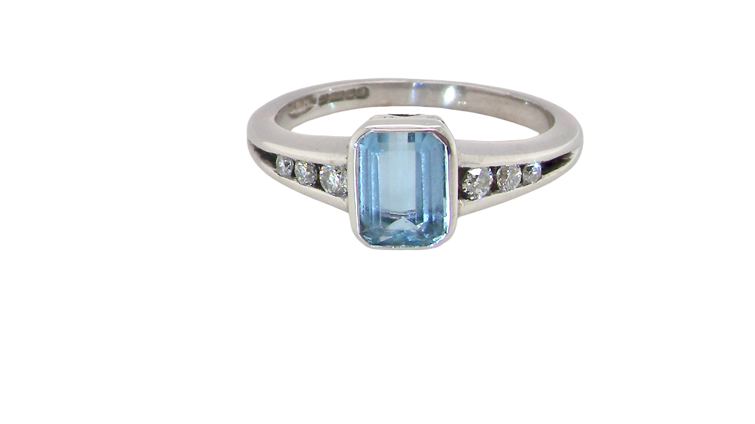 An 18 carat white gold ring, features a rectangular step cut aquamarine, measures 7x5mm (st one carat) sky blue, fine clarity. Rim setting.