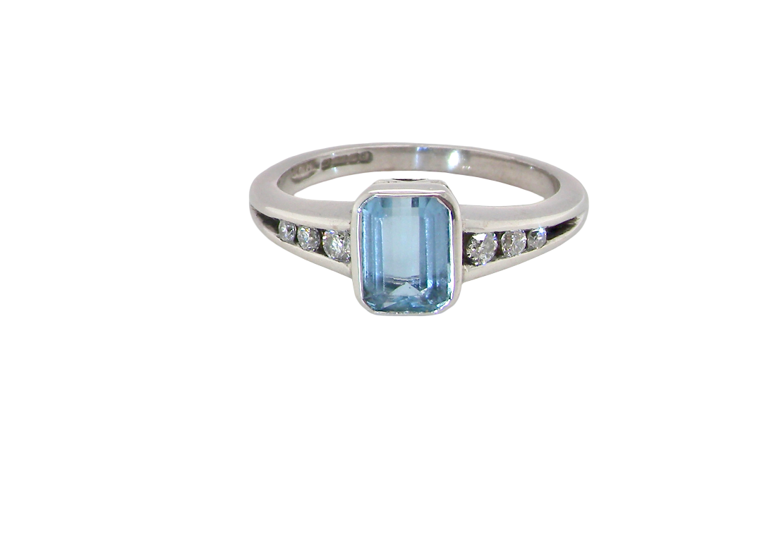 An 18 carat white gold ring, features a rectangular step cut aquamarine, measures 7x5mm (st one carat) sky blue, fine clarity. Rim setting.