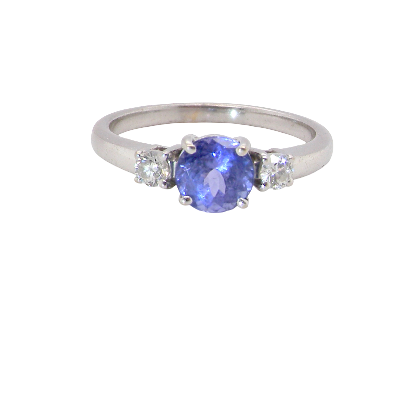 An 18 carat white gold three stone ring. Centre stone a round tanzanite 6mm diameter.
Each side a brilliant cut white diamond
