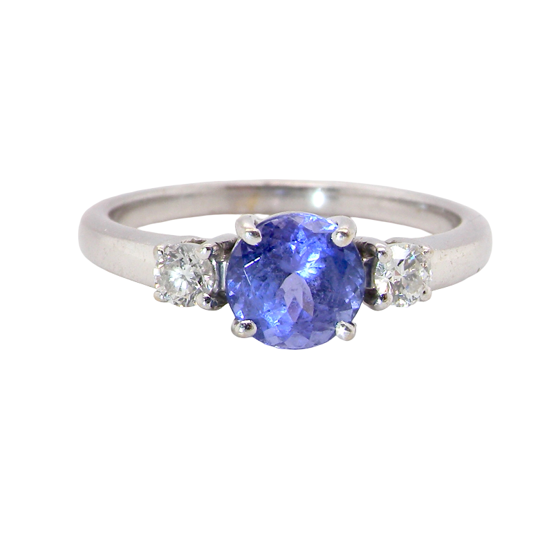 An 18 carat white gold three stone ring. Centre stone a round tanzanite 6mm diameter.
Each side a white diamond