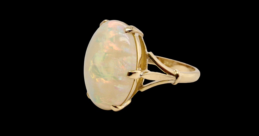 An 18 carat yellow gold* dress ring set with a large oval opal gemstone. side