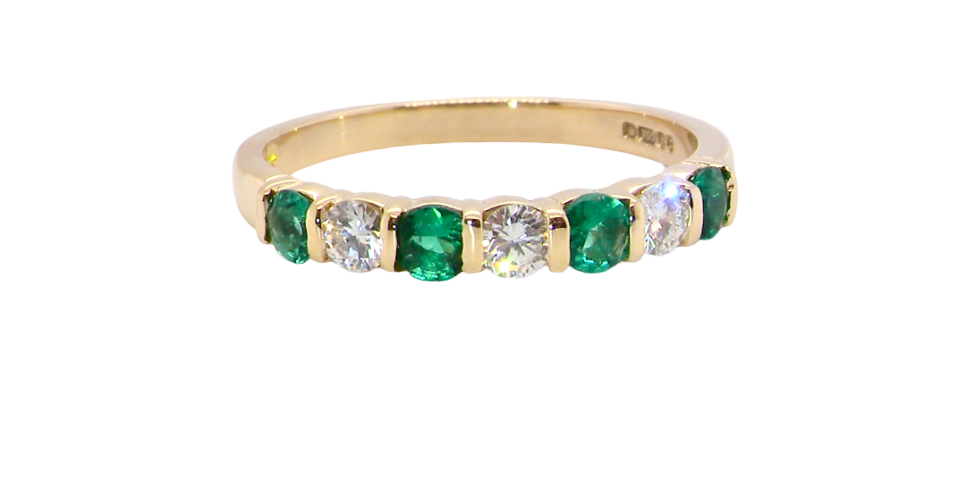 An 18 carat yellow gold half hoop eternity ring. Set with four bright green emeralds, each 3mm diameter .