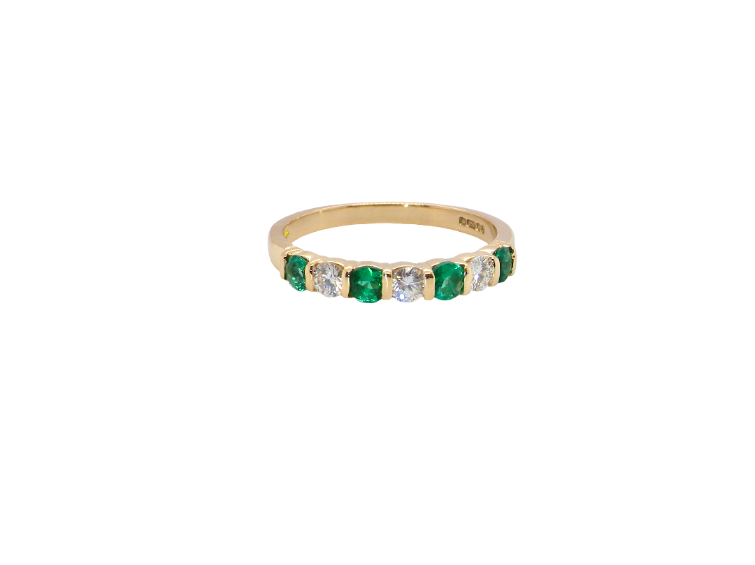 An 18 carat yellow gold half hoop eternity ring. Set with four bright green emeralds, each 3mm diameter (est each 0.10 carats) .