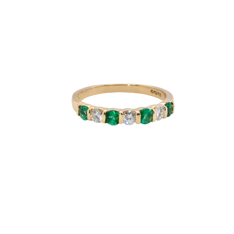 An 18 carat yellow gold half hoop eternity ring. Set with four bright green emeralds, each 3mm diameter (est each 0.10 carats) .