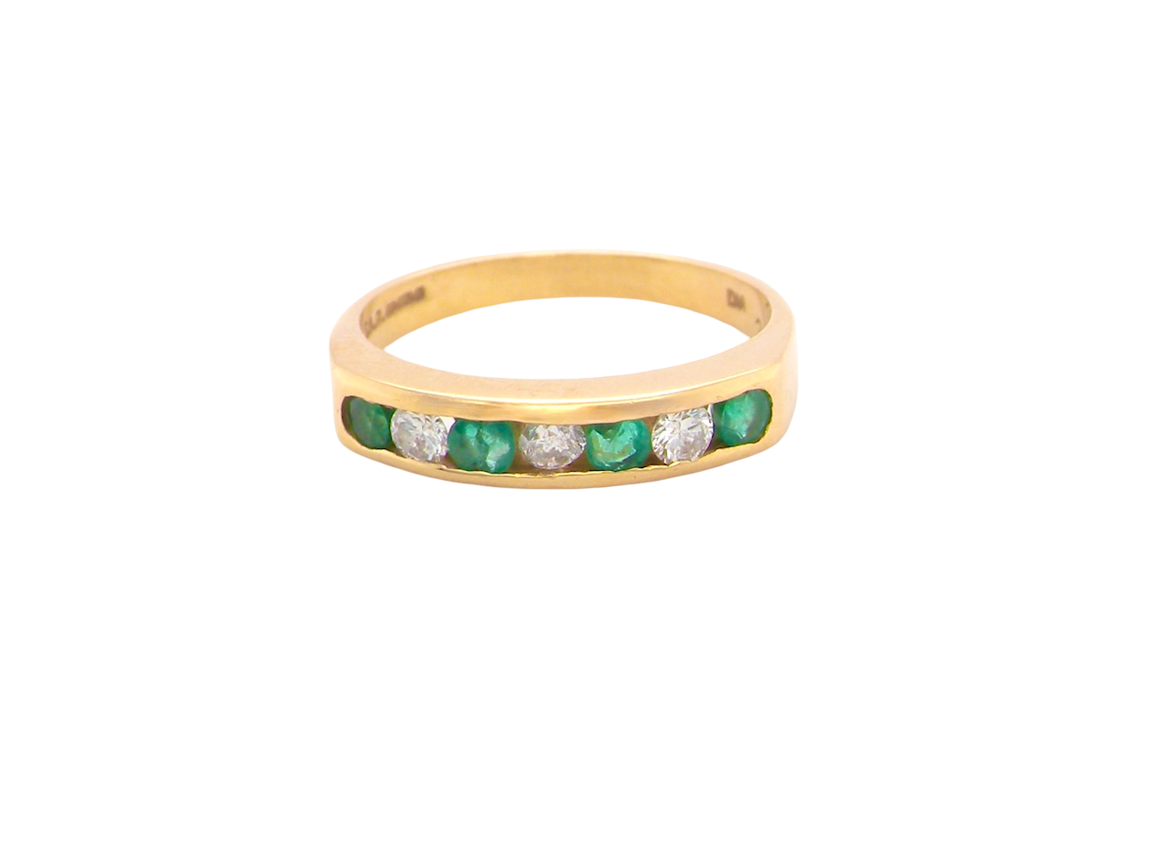 An 18 carat yellow gold half hoop eternity ring. Set with four round emeralds, each 3mm, and alternate set with brilliant cut white diamonds, each 3mm (total est 0.30 carats)