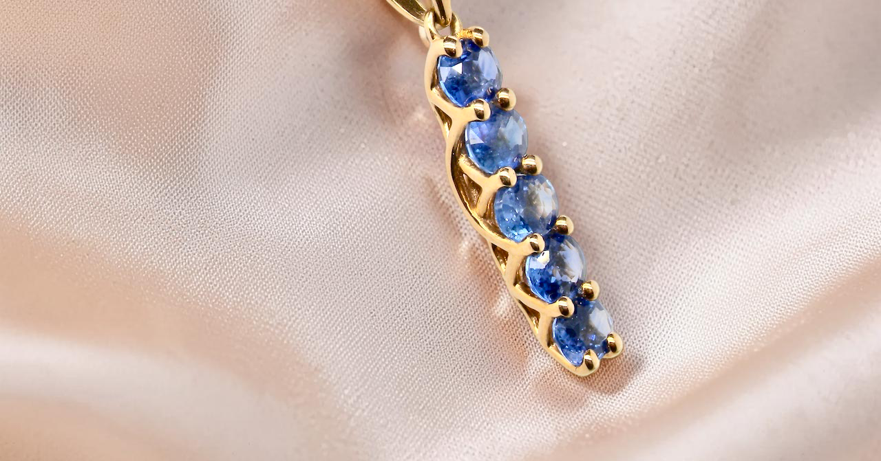 An 18 carat yellow gold pendant. This features five oval cut sapphires, each 5x3.5mm. 
