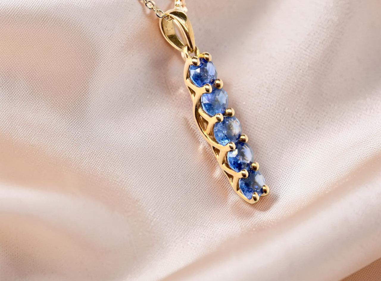 An 18 carat yellow gold pendant. This features five oval cut sapphires, each 5x3.5mm. 