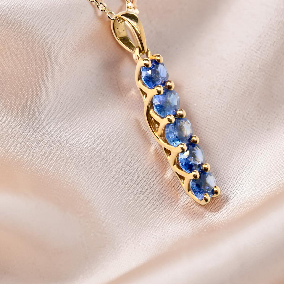 An 18 carat yellow gold pendant. This features five oval cut sapphires, each 5x3.5mm. 