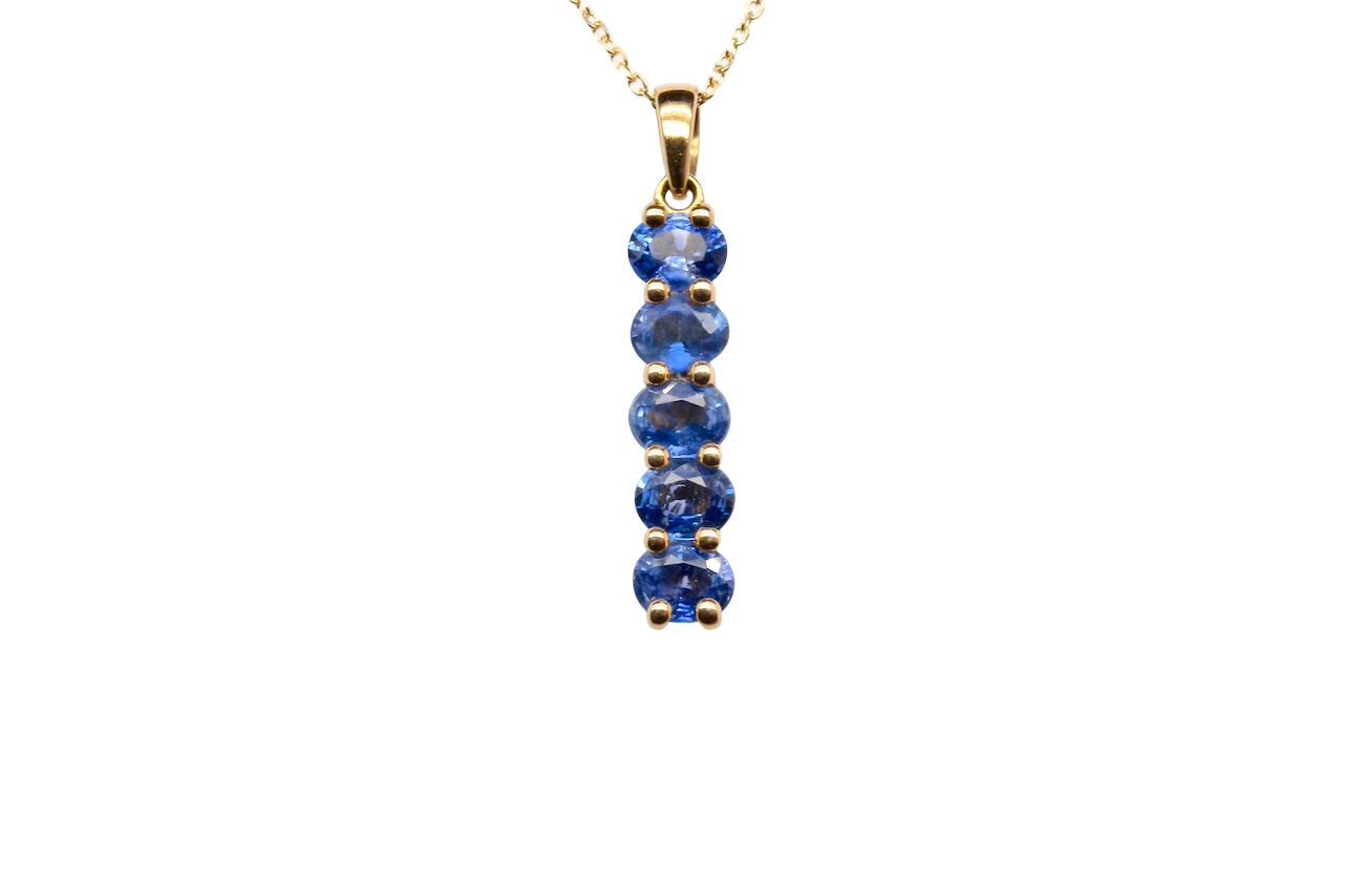 An 18 carat yellow gold pendant. This features five oval cut mid cornflower blue sapphires,