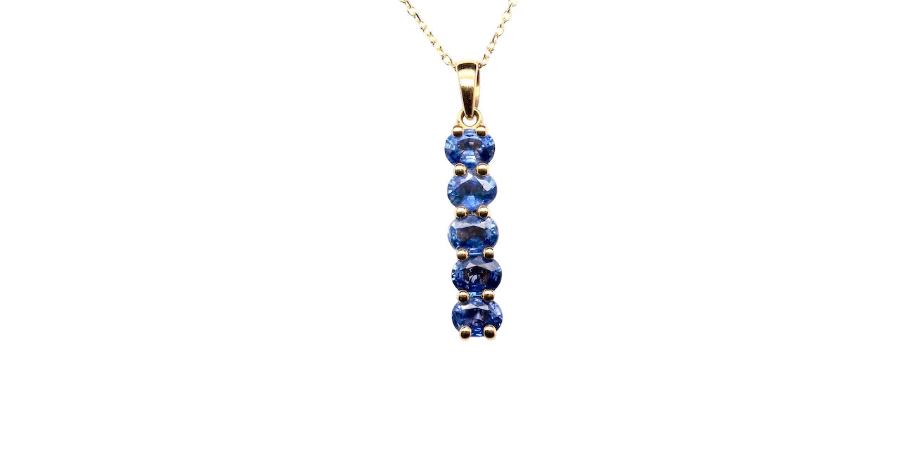 An 18 carat yellow gold pendant. This features five oval cut mid cornflower blue sapphires, each 5x3.5mm. 