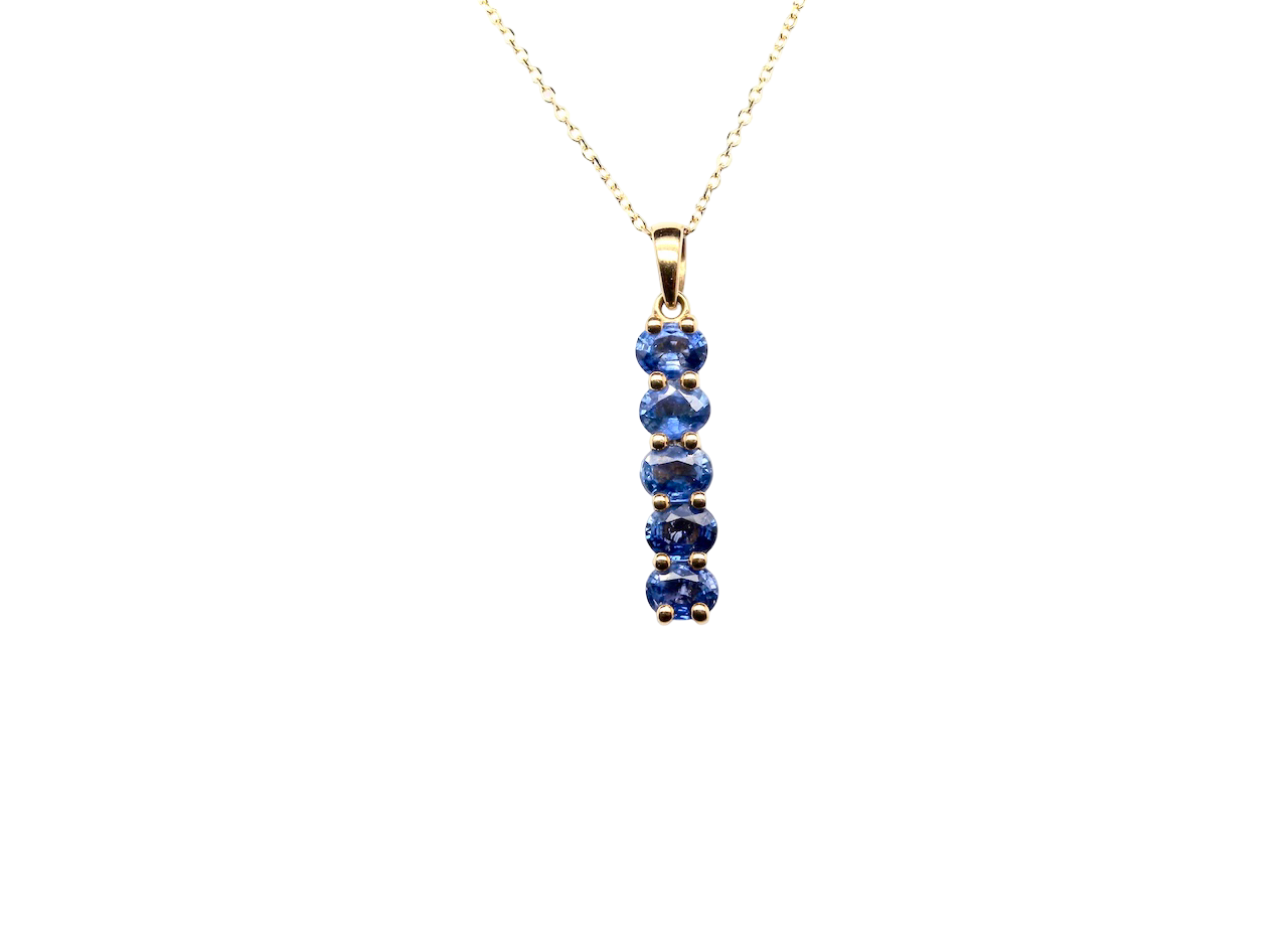 An 18 carat yellow gold pendant. This features five oval cut mid cornflower blue sapphires, each 5x3.5mm. 
