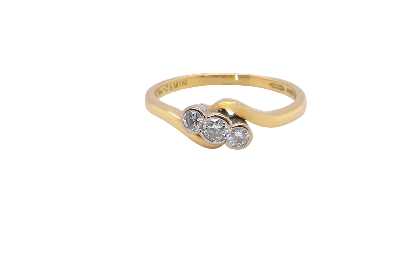 An 18 carat yellow gold three stone ring, cross over style, and set with brilliant cut white diamonds.
Centre stone 3mm (0.10 carats)