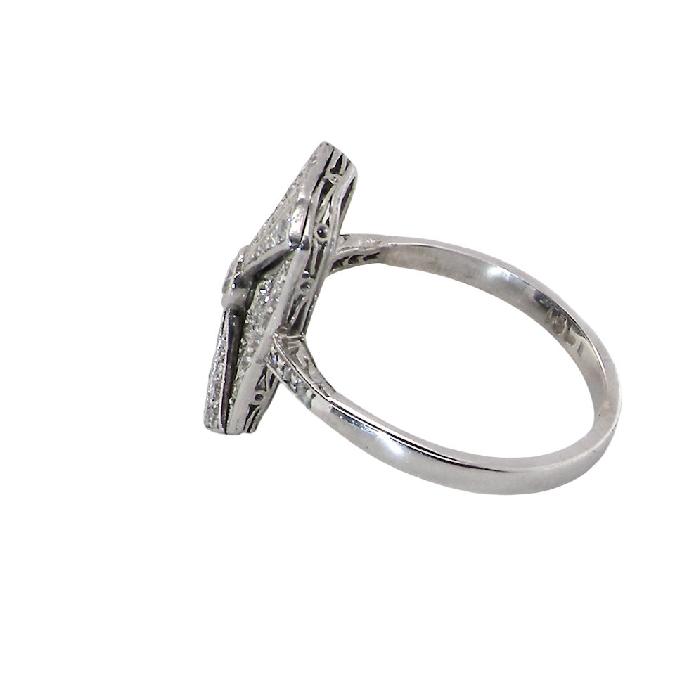 An Art Deco panel shaped cluster ring. The head measures 16x10mm, depth 3.4mm, and has two fan shaped designs that feature above and below a brilliant cut white diamond centre stone which measures 3.4mm (0.15 carats est)
side