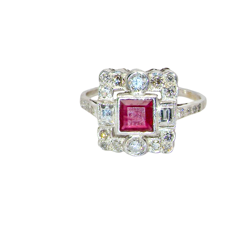 An Art Deco style cluster ring. Set to the centre a square 5x5mm ruby, rub over setting and complimented by a surround of mixed cut white diamonds.