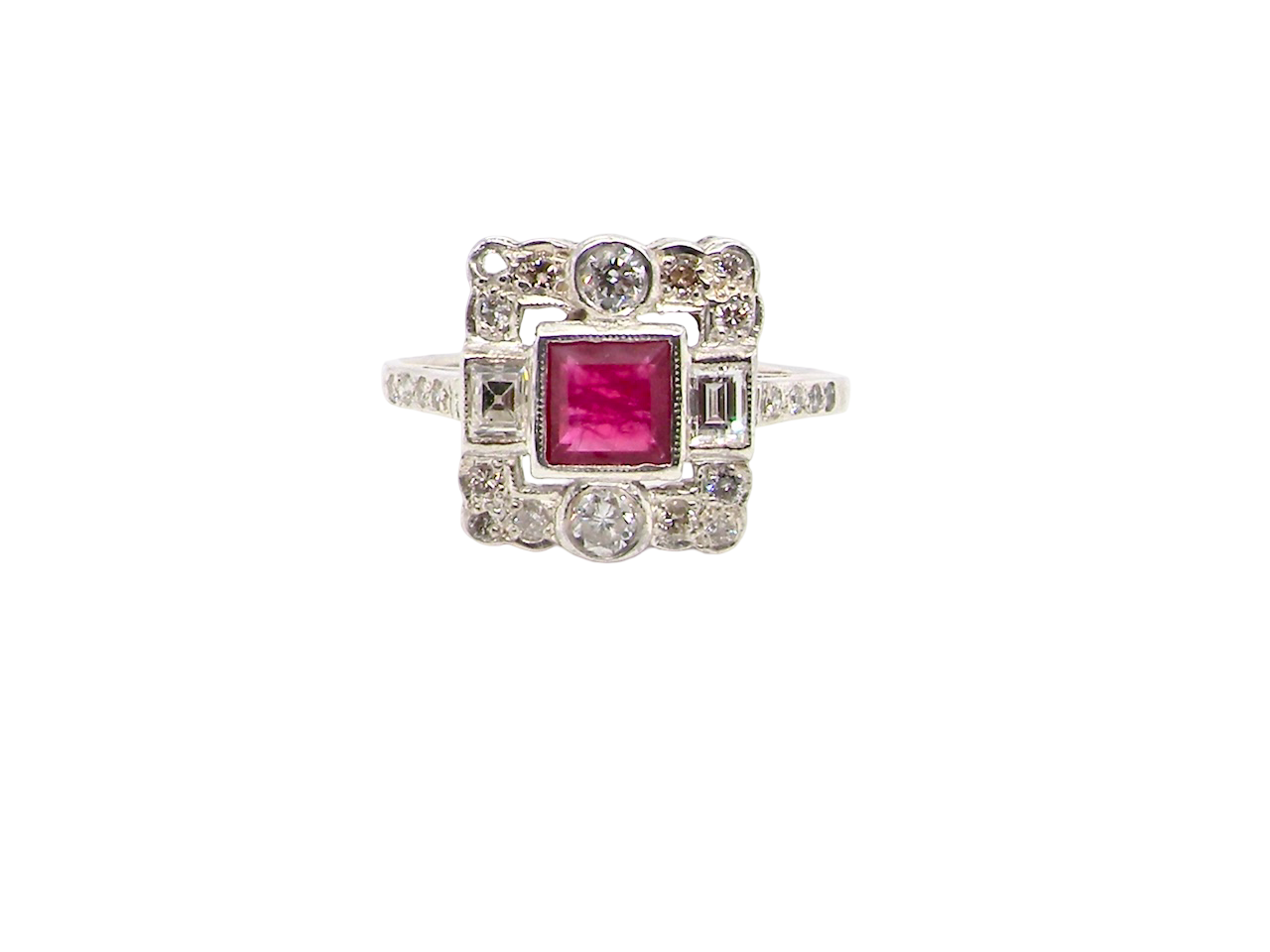 An Art Deco style cluster ring. Set to the centre a square 5x5mm ruby, rub over setting and complimented by a surround of white diamonds.