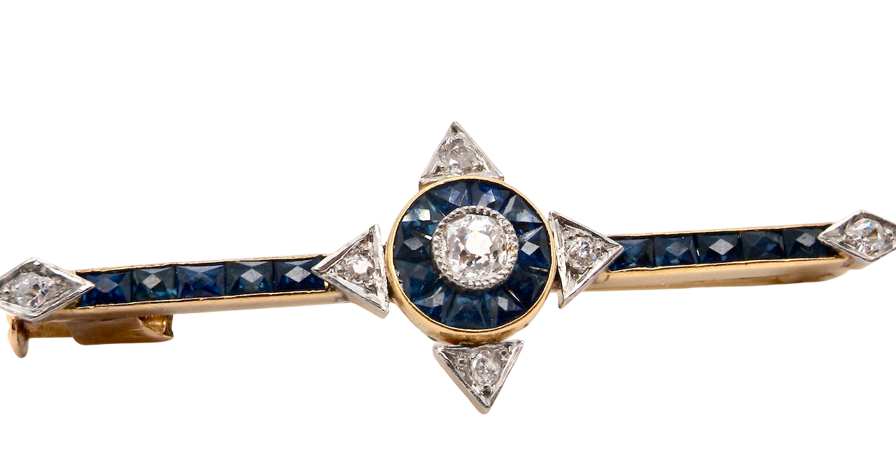 An Edwardian bar brooch. The centre 'target' style portion is set with a brilliant cut white diamond 4mm (0.25 carats) colour H-j, clarity Si.
