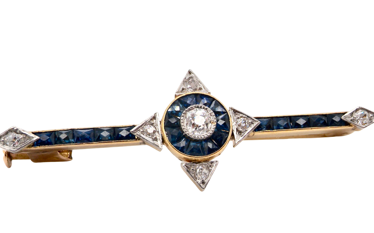 An Edwardian bar brooch. The centre 'target' style portion is set with a brilliant cut white diamond 4mm (0.25 carats) colour H-j, clarity Si.