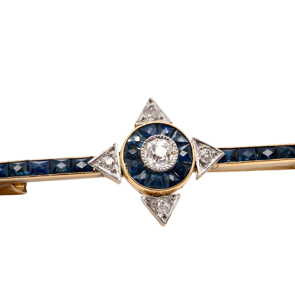 An Edwardian bar brooch. The centre 'target' style portion is set with a brilliant cut white diamond 4mm (0.25 carats) colour H-j, clarity Si.