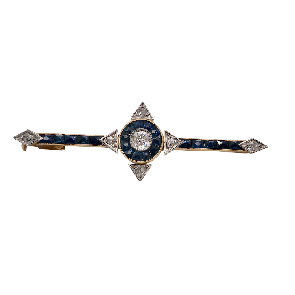 An Edwardian bar brooch. The centre 'target' style portion is set with a brilliant cut white diamond 4mm (0.25 carats) colour H-j, clarity Si. Mille grain setting.