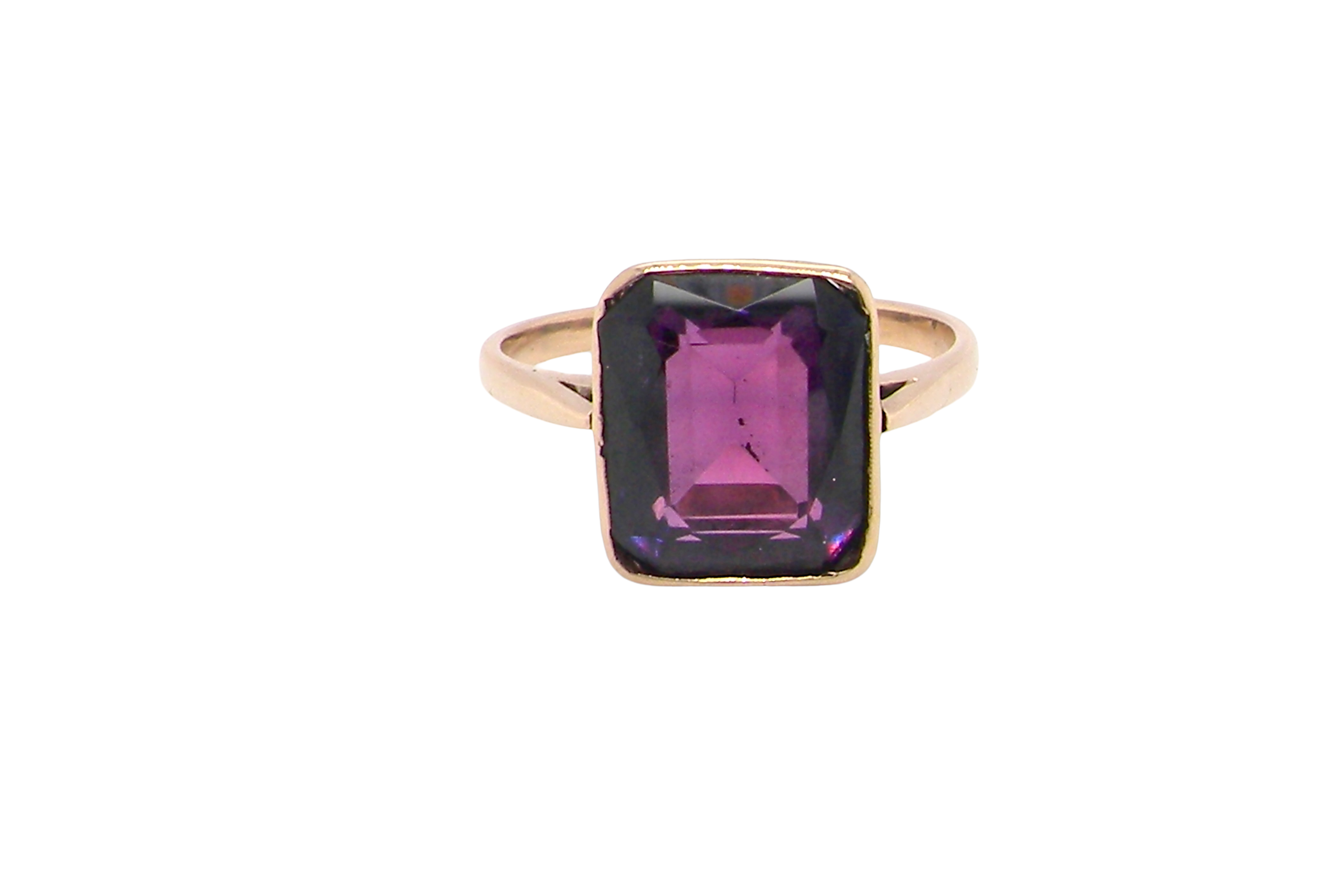 An antique dress ring that features a rectangular cut amethyst. Very dark purple, measures 12x10mm. Rim setting.