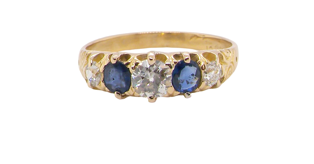An antique ring from the early years of the 20th century. Centre stone 5mm diameter (0.50 carats) Colour H-j, clarity Si. Each side blue sapphire 4mm diameter.
