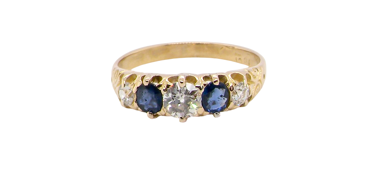 An antique ring from the early years of the 20th century. Centre stone 5mm diameter (0.50 carats) Colour H-j, clarity Si. Each side a mid colour blue sapphire 4mm diameter.