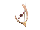 Gold brooch with embedded gemstones on a white background