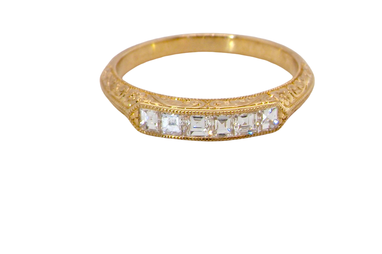 An attractive half hoop diamond eternity ring. Set with six step cut white diamonds, sit side by side, the colour estimated at H-i, clarity Si.