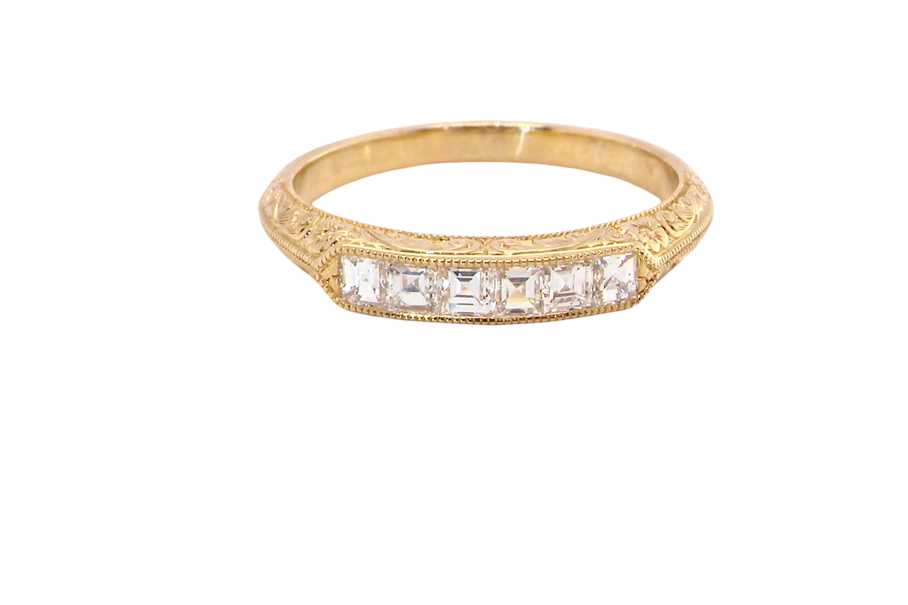 An attractive half hoop diamond eternity ring. Set with six step cut white diamonds, sit side by side, the colour estimated at H-i, clarity Si.