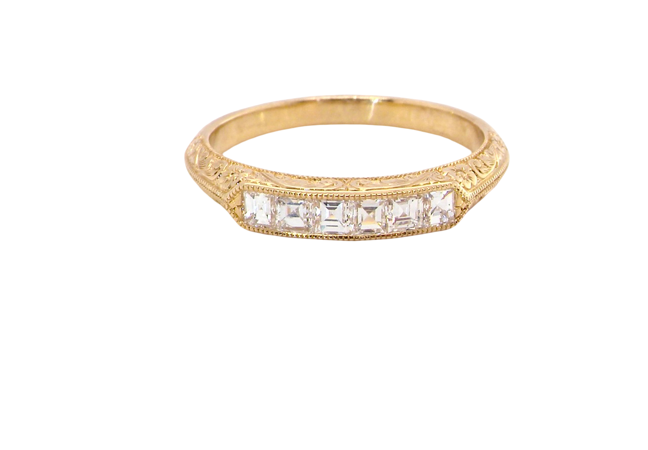 An attractive half hoop diamond eternity ring. Set with six step cut white diamonds, sit side by side, the colour estimated at H-i, clarity Si.