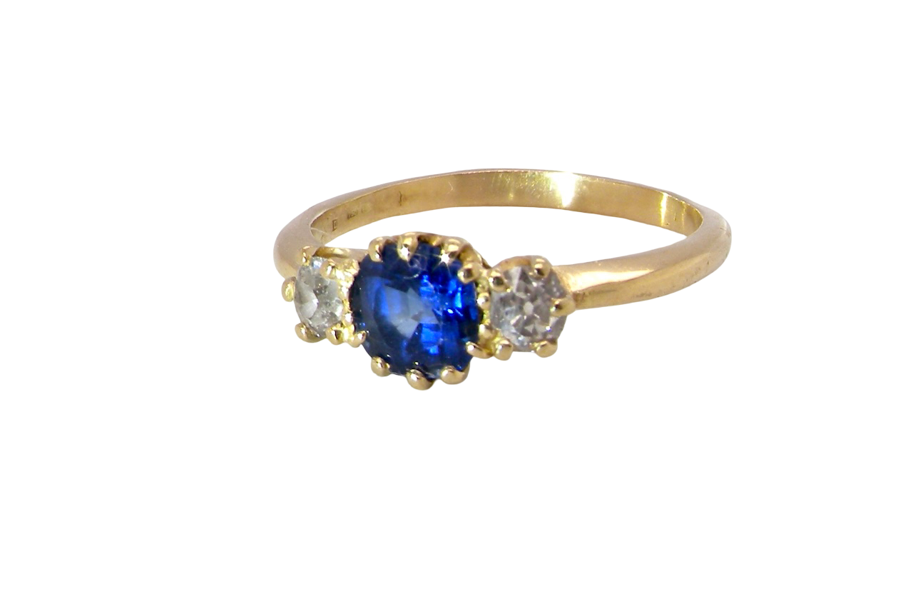 An early 20th-century trilogy ring set with a cornflower blue central sapphire,
