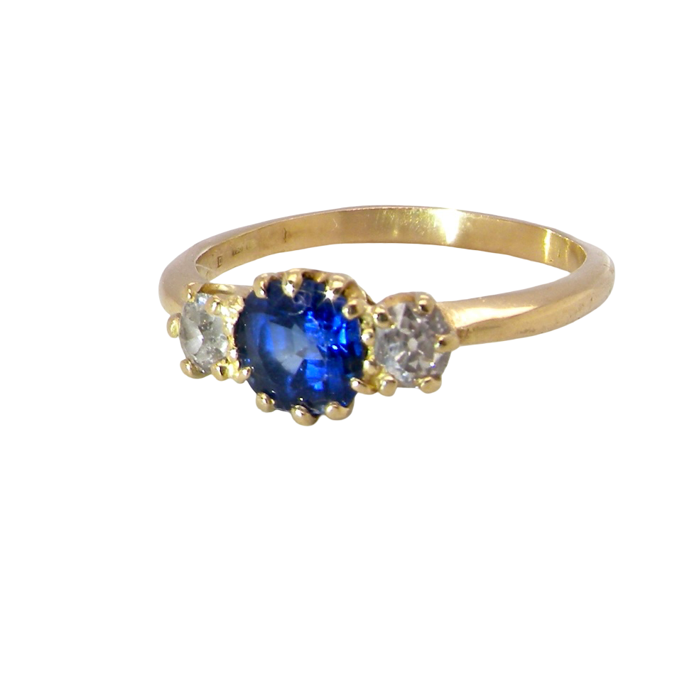 An early 20th-century trilogy ring set with a cornflower blue central sapphire,