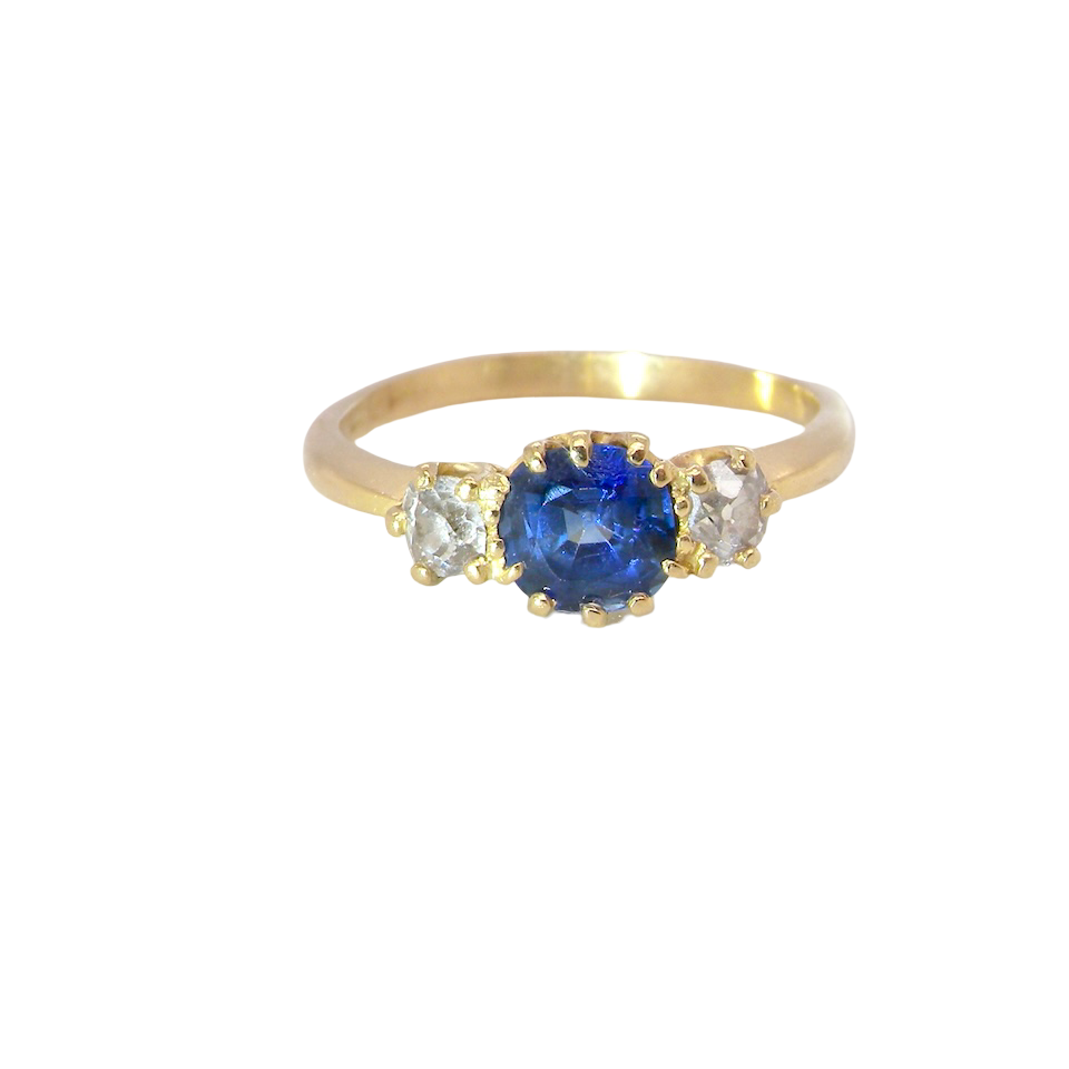 An early 20th-century trilogy ring set with a mid to dark cornflower blue central sapphire,