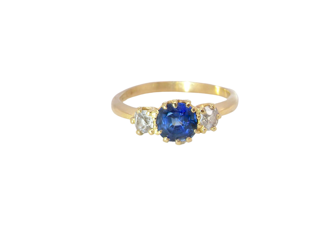 An early 20th-century trilogy ring set with a mid to dark cornflower blue central sapphire,