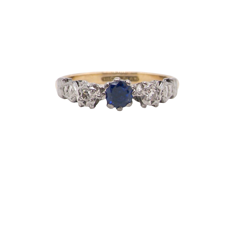An early 20th century engagement ring. The centre stone a dark blue sapphire