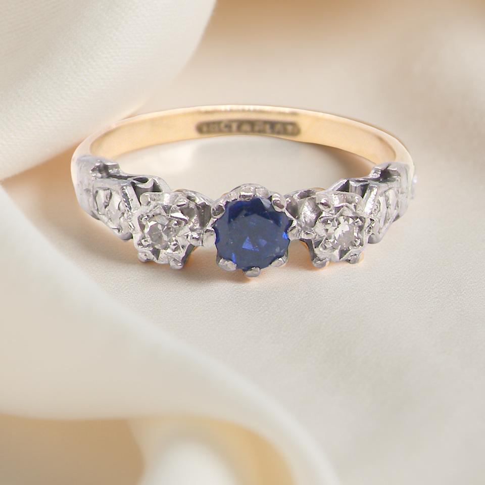 An early 20th century engagement ring. centre stone a dark blue sapphire