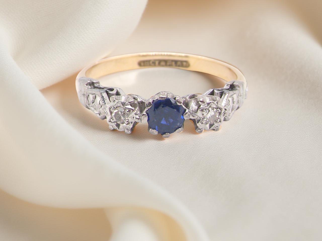 An early 20th century engagement ring. centre stone a dark blue sapphire
