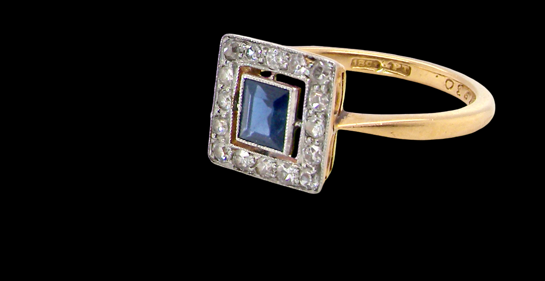 An early 20th century square cluster ring. Features a square inky black blue sapphire, 4x4mm (est 0.25 carats) mille grain set.side