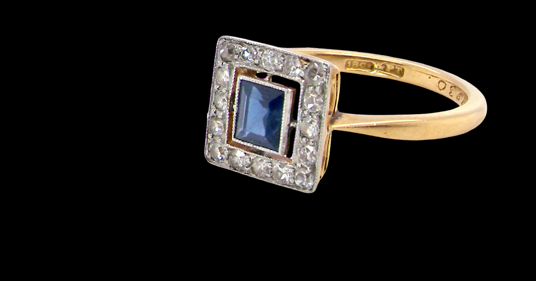 An early 20th century square cluster ring. Features a square inky black blue sapphire, 4x4mm (est 0.25 carats) mille grain set.side
