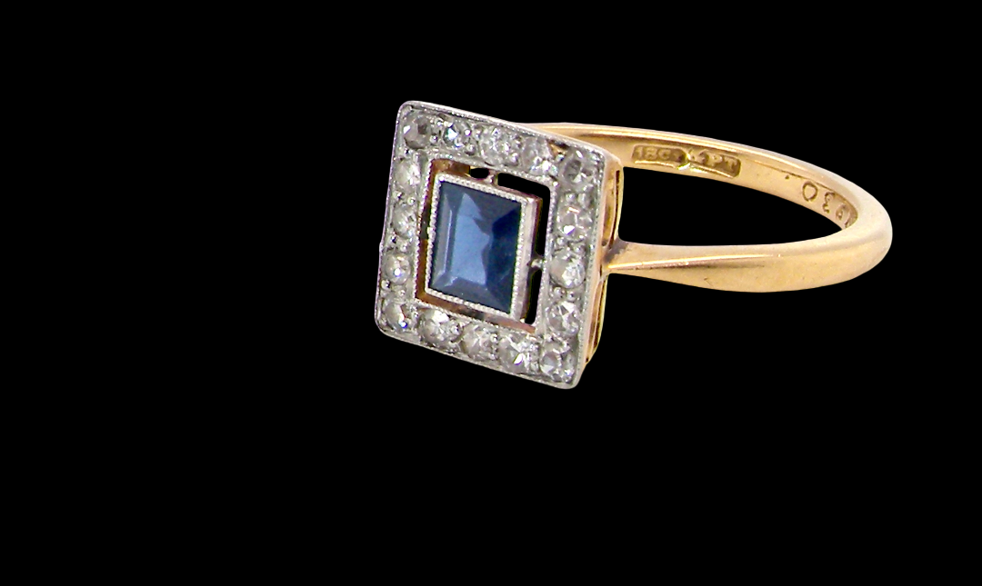 An early 20th century square cluster ring. Features a square inky black blue sapphire, 4x4mm (est 0.25 carats) mille grain set.side