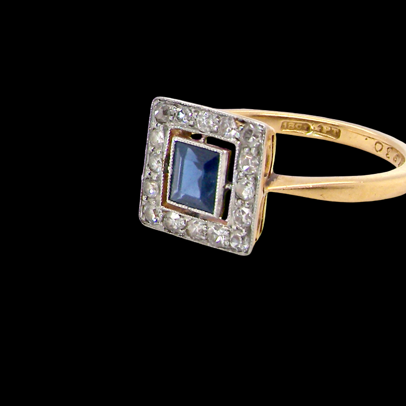 An early 20th century square cluster ring. Features a square inky black blue sapphire, 4x4mm (est 0.25 carats) mille grain set.side