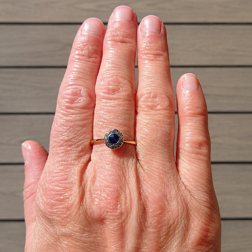 An Edwardian sapphire and diamond ring on a hand