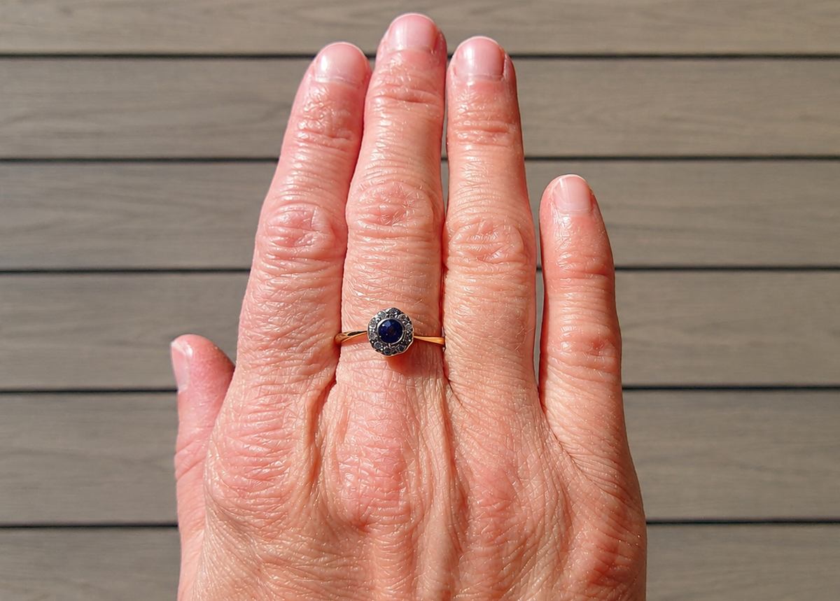 An Edwardian sapphire and diamond ring on a hand