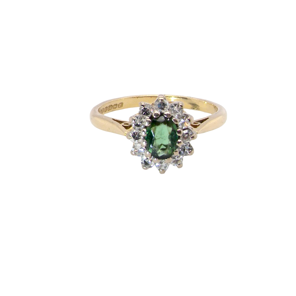An elegant 18 carat gold cluster ring featuring a beautifully proportioned 6 × 4mm green tourmaline