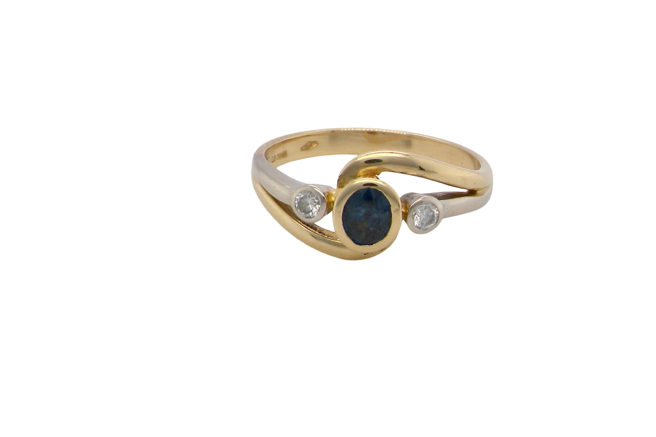 An elegant 18 carat gold three-stone ring featuring a rich, oval-cut dark blue sapphire at the centre, measuring 5 × 4mm, secured in a classic rim (bezel) setting.