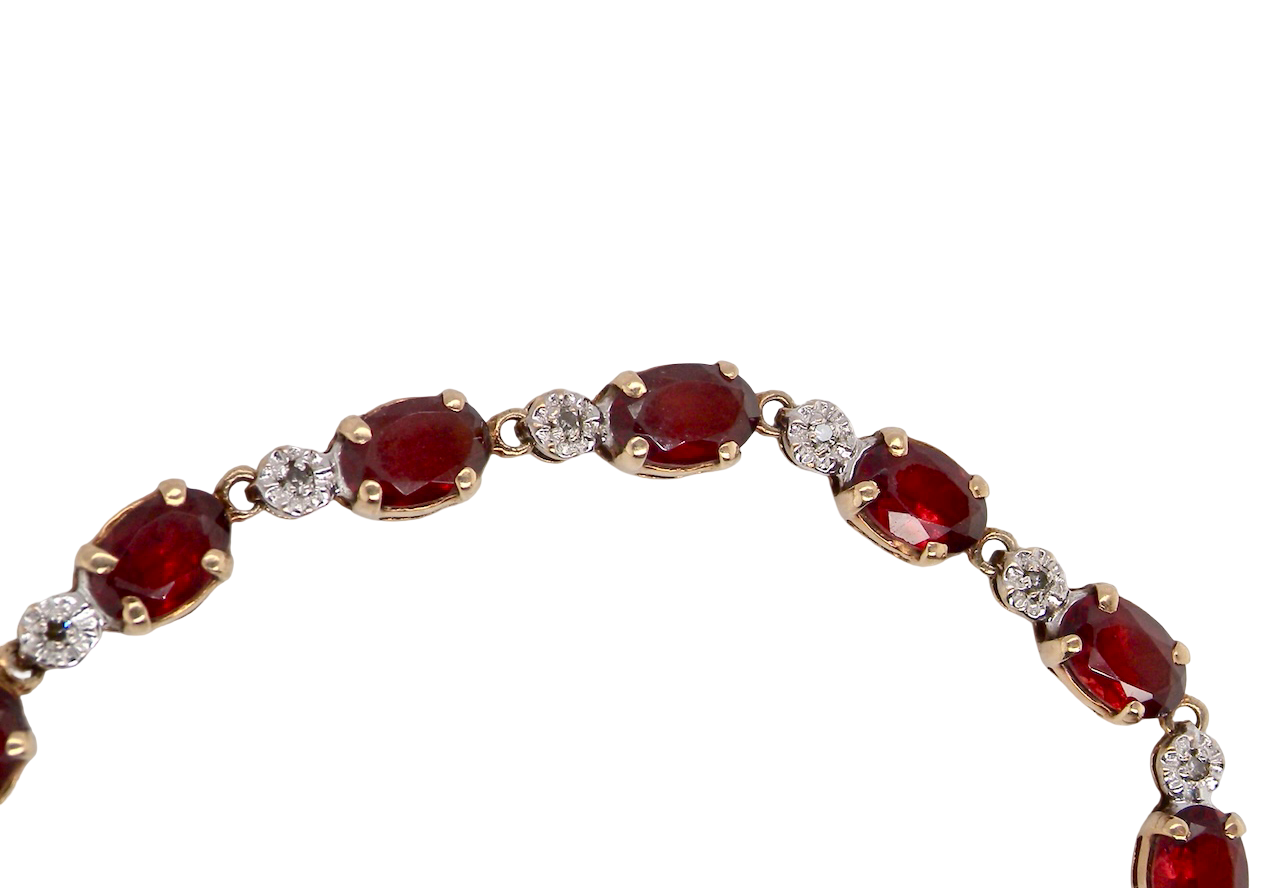 An elegant 9 carat gold bracelet set with sixteen rich red oval-cut garnets, each measuring approximately 6 x 4mm. Between each garnet sits a delicate illusion-set diamond in white gold, creating the appearance of larger stones