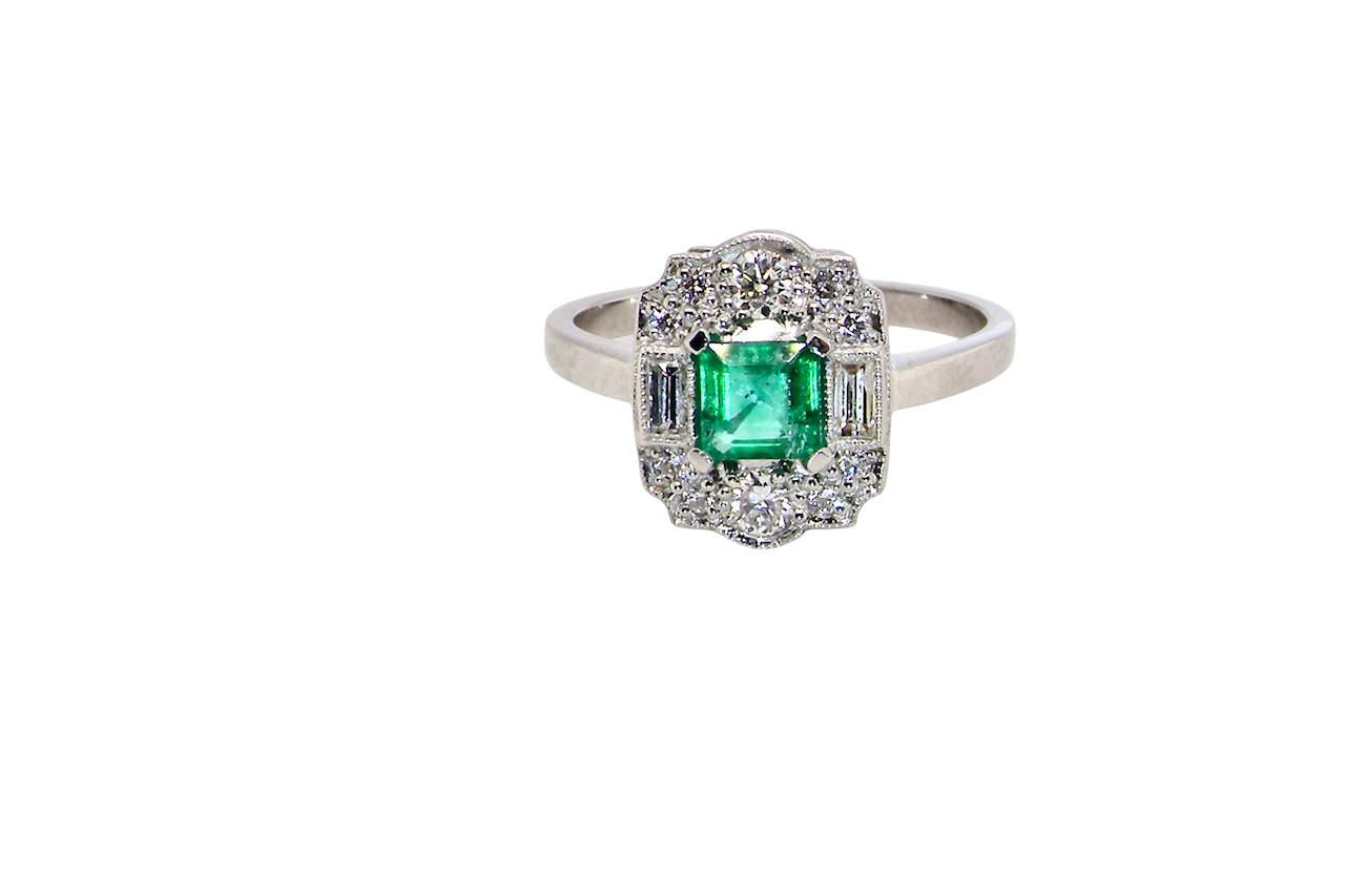 An elegant Art Deco–style cluster ring of plaque design, centred with a square step-cut emerald measuring approximately 4.5 × 4.5 mm (estimated 0.40 carats). The emerald displays a vibrant, lively green colour and is beautifully framed by diamonds.